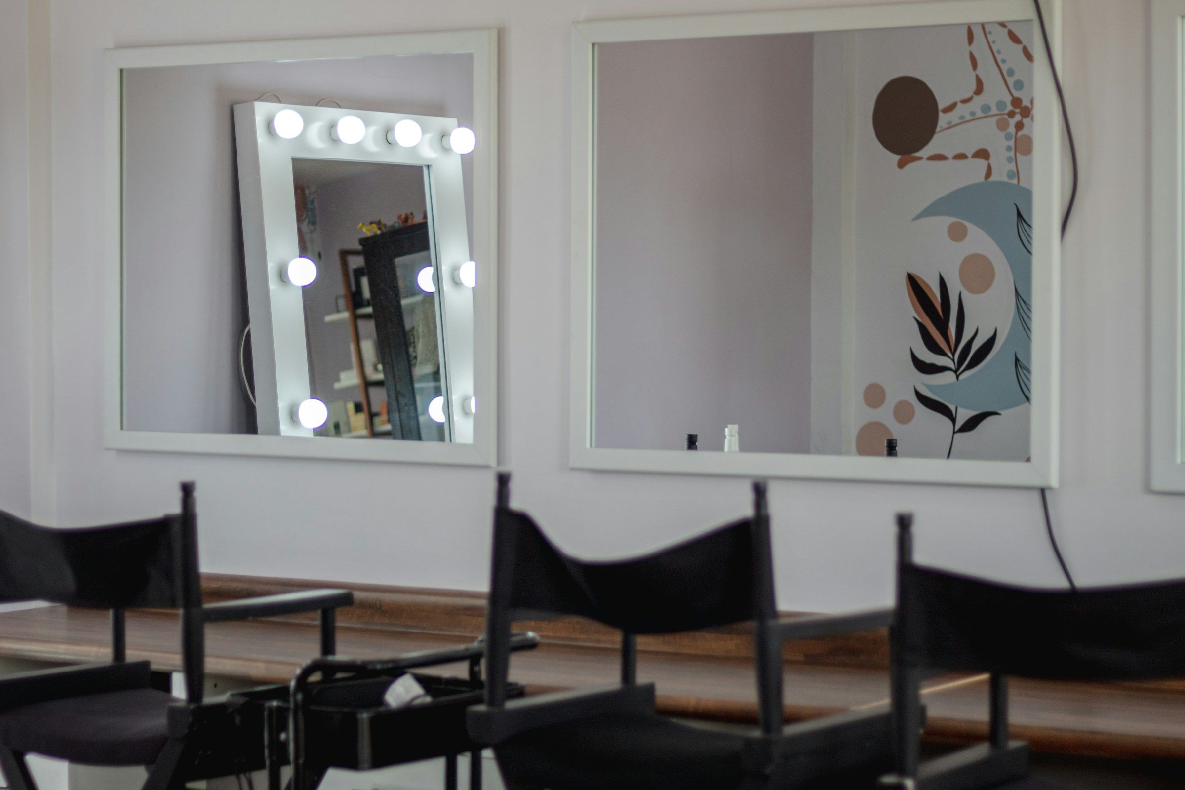 Heller Salon mit zwei Wandspiegeln und einem Spiegel mit Lampen
